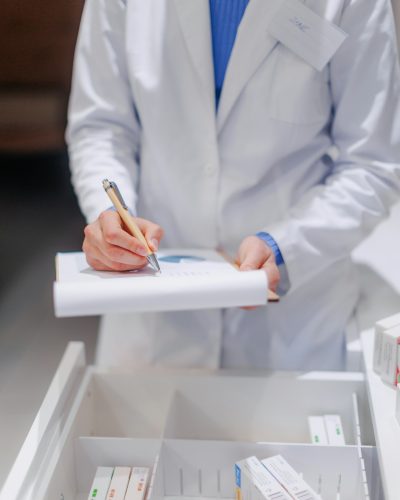 Pharmacist checking medicine stock in a pharmacy.